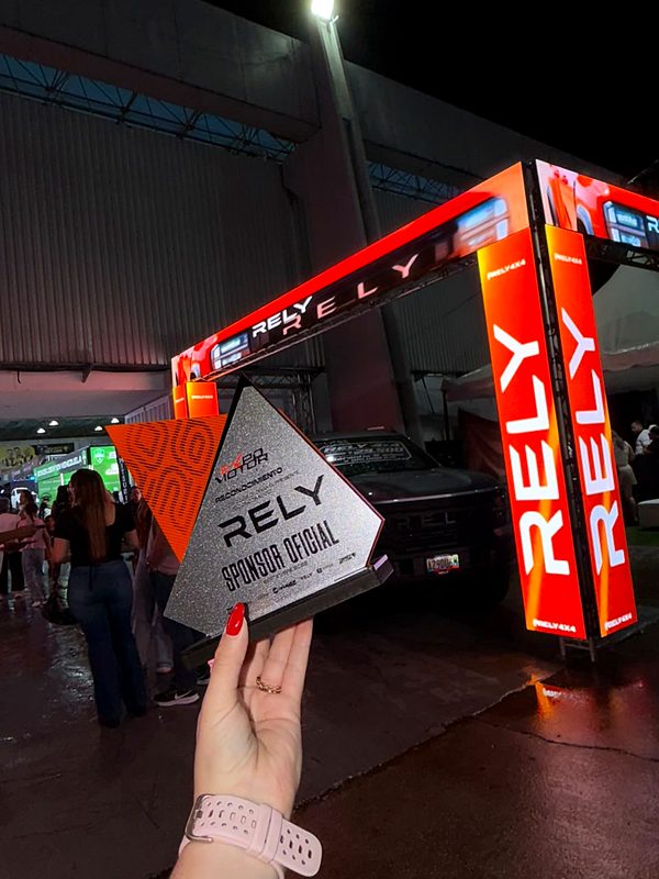 Trofeo RELY Sponsor Oficial de la Expo Motor Táchira 2026 frente al arco LED del stand