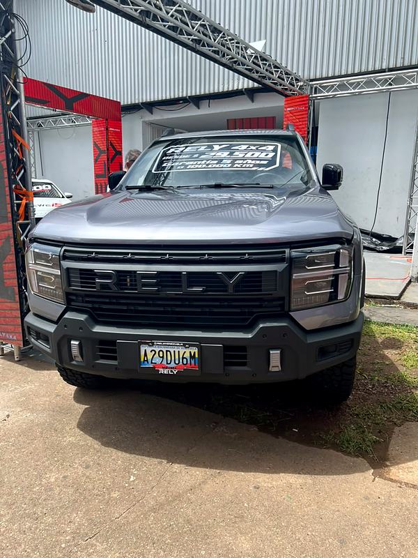 RELY R8 gris de frente en la Expo Motor Táchira con letrero de precio y garantía en el parabrisas