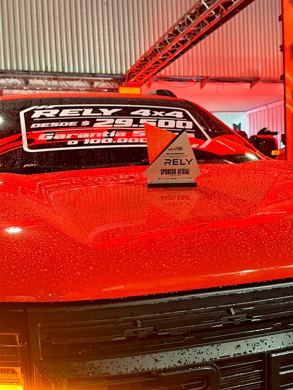 Trofeo RELY Sponsor Oficial sobre el capó de la RELY R8 naranja en la Expo Motor Táchira
