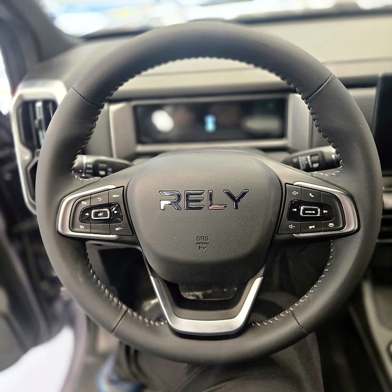 Volante multifunción forrado de la RELY R8 con el logo RELY y el cuadro digital al fondo
